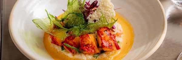 A round plate with lobster risotto in it at The Collins Room at The Berkeley